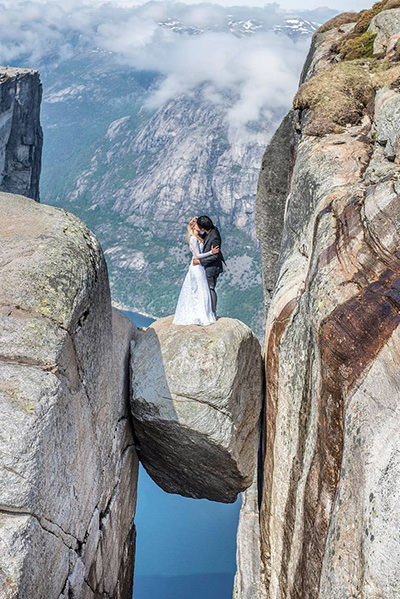 Marta Sibielak and Keow Wee Loong in their ceremony clothes posing for the wedding photo on Kjeragbolten boulder in Norway; private album. 
