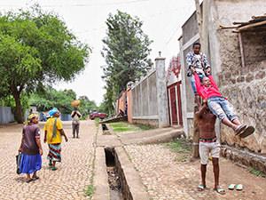 One of the "Circus of Postcards" postcards: Arba Minch Circus acrobats performing in the street of Arba Minch, Ethiopia, while the surprises passers-by watch, photo by Ivan Kralj