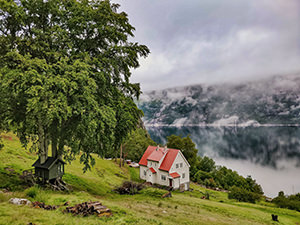 Treehouse and Director's Villa with foggy mountain and calm waters of Lysefjord in the background, at Flørli 4444, in Norway, photo by Ivan Kralj