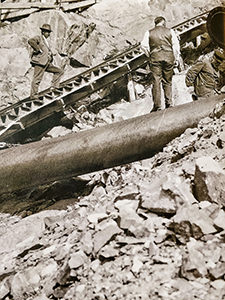 Black and white photo of workers laying the pipeline for Flørli power plant, next to the wooden staircase, the longest staircase in the world, at Lysefjord, Norway