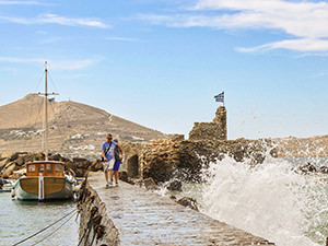 Tourists crossing the walkway to Venetian Castle in Naoussa, trying to avoid the splashes of the sea waves, photo by Ivan Kralj