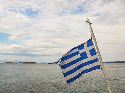 Greek flag on the pole with a cross, on the ferry to Mount Athos, the peninsula of monasteries in Greece, photo by Ivan Kralj