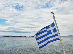 Greek flag on the pole with a cross, on the ferry to Mount Athos, the peninsula of monasteries in Greece, photo by Ivan Kralj
