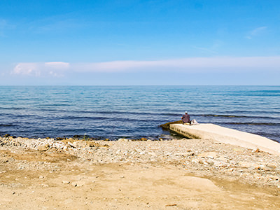 A man sitting on the pier in front of the Iviron Monastery. on Mount Athos, the Holy Mountain peninsula in Greece, photo by Ivan Kralj