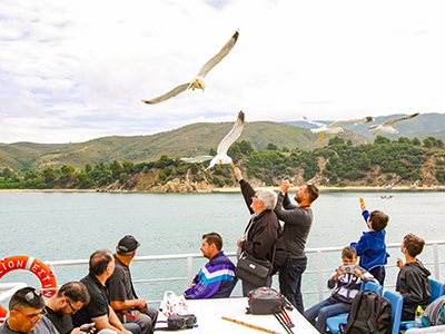 Men feeding seagulls on the ferry to Mount Athos, the Holy Mountain in Greece, photo by Ivan Kralj