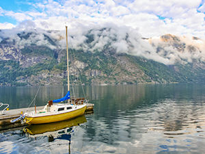 Boat in Aurlandsfjord surrounded by cloudy mountains, at Aurlandsvangen, Aurland, Norway, photo by Ivan Kralj