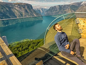 Pipeaway blogger Ivan Kralj resting his head and back on the angled glass pane at the end of the Stegastein lookout in Aurland, Norway, photo by Ivan Kralj