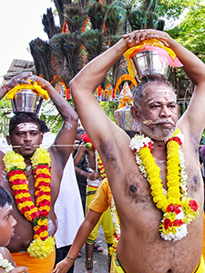 Friends Kumar and Govindarajoo, with pierced tongue and cheek, and paal kudam - milk pots on their head, walking in a procession to Batu Caves at Thaipusam Festival 2019, photo by Ivan Kralj