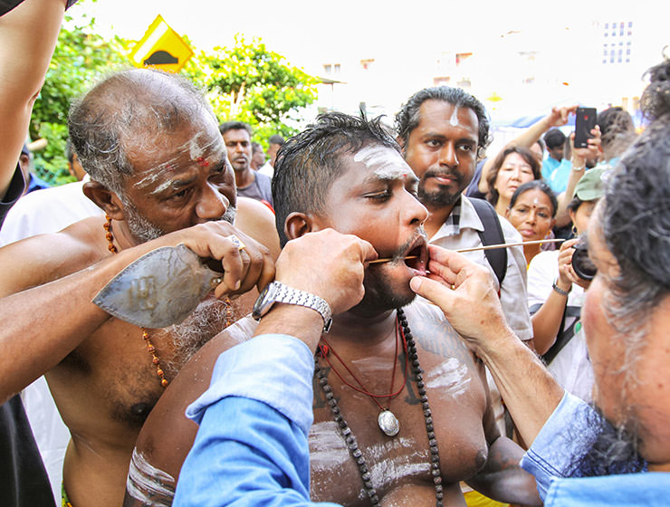 Piercing the cheeks of a devotee with a rod at Thaipusam Festival 2019 at Batu Caves, photo by Ivan Kralj