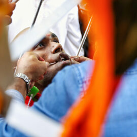 Piercing the cheek of a devotee with a skewer at Thaipusam Festival 2019 at Batu Caves, Malaysia, photo by Ivan Kralj