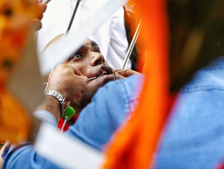 Piercing the cheek of a devotee with a skewer at Thaipusam Festival 2019 at Batu Caves, Malaysia, photo by Ivan Kralj