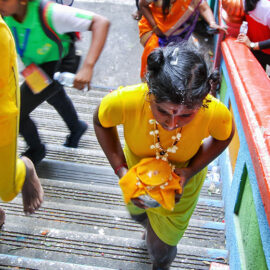 Little girl devotee carrying paal kudam climbing the 272 stairs to Batu Caves, Malaysia, during the Thaipusam Festival 2019, photo by Ivan Kralj