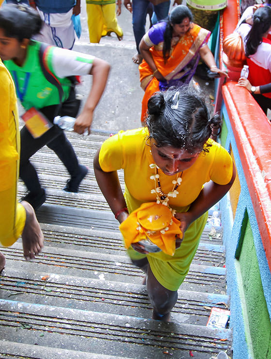 Little girl devotee carrying paal kudam climbing the 272 stairs to Batu Caves, Malaysia, during the Thaipusam Festival 2019, photo by Ivan Kralj