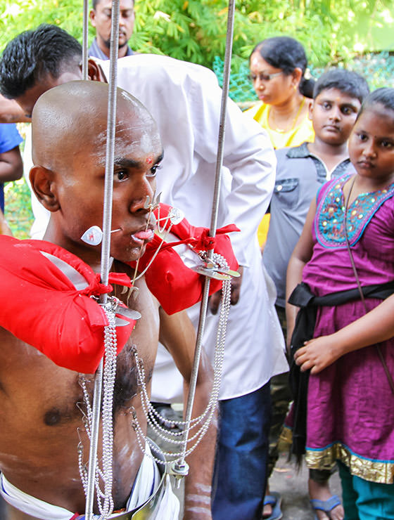Prakash J Govindarajoo posing with pierced tongue and cheeks at Thaipusam Festival 2019 at Batu Caves, Malaysia, photo by Ivan Kralj