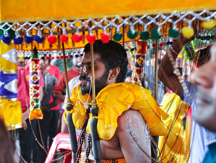 Devotee with pierced tongue and cheeks, carrying a kavadi at Thaipusam Festival 2019 at Batu Caves, Malaysia, photo by Ivan Kralj