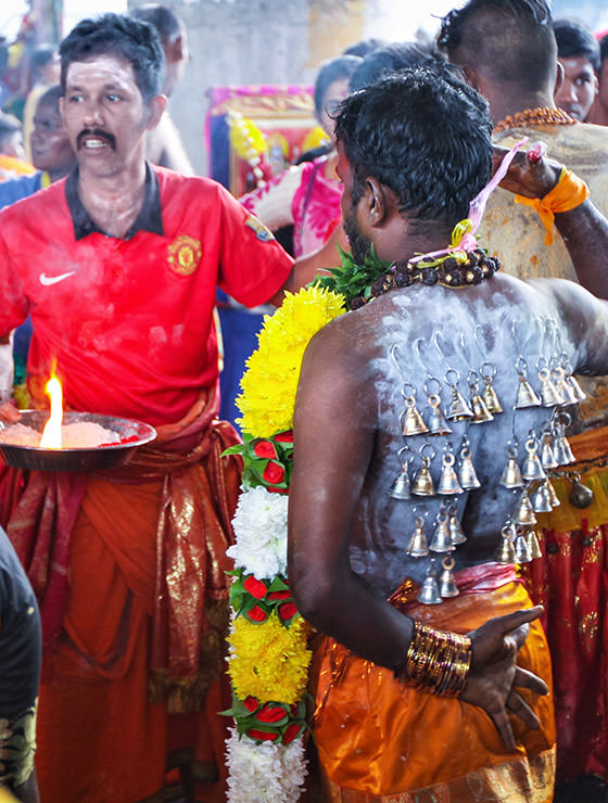 Devotee with bells pierced through the skin of his back at Thaipusam Festival 2019 at Batu Caves, Malaysia, photo by Ivan Kralj