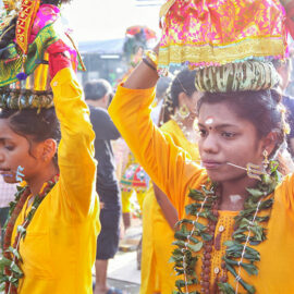 Two female devotees with pierced tongues carrying paal kudam at Thaipusam Festival 2019 at Batu Caves, Malaysia, photo by Ivan Kralj