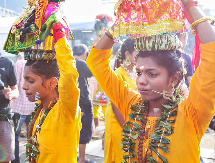 Two female devotees with pierced tongues carrying paal kudam at Thaipusam Festival 2019 at Batu Caves, Malaysia, photo by Ivan Kralj