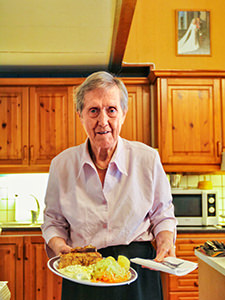 An 85-year-old Randi Bjelland presenting a fish dish at her homey kitchen in Bergen, Norway, photo by Ivan Kralj