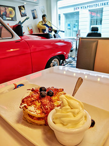 Pancakes with bacon and soft ice-cream served in the retro ambient of Roll & Rock American Diner in Bergen, Norway, with Cadillac and Elvis Presley sculpture in the background, photo by Ivan Kralj