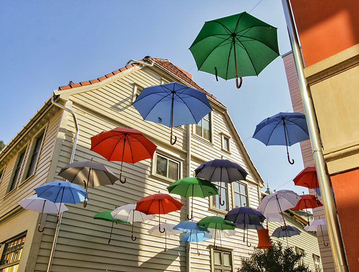 Decorative umbrellas floating in the air above one bar in Bergen, the rainiest city in Europe, photo by Ivan Kralj