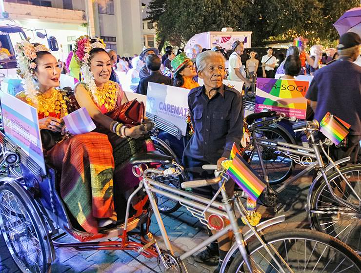 Two ladies sitting in rainbow-adorned the tuk-tuk at Chiang Mai Pride, gay parade in Chiang Mai, Thailand, photo by Ivan Kralj
