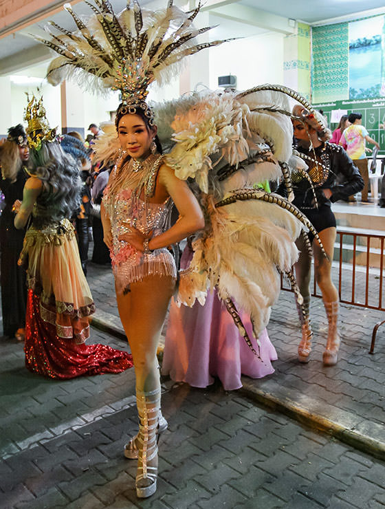 Participant dressed in feathers posing at Chiang Mai Pride, gay parade in Chiang Mai, Thailand, photo by Ivan Kralj
