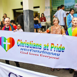 A priest and other participants with a sign "Christians at Pride: God loves everyone", posing at Chiang Mai Pride, gay parade in Chiang Mai, Thailand, photo by Ivan Kralj