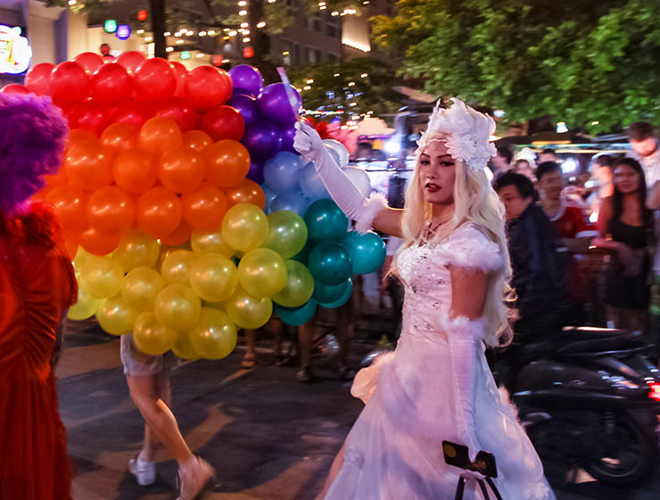 Participant in the white wedding dress in front of the rainbow-colored balloons at Chiang Mai Pride, gay parade in Chiang Mai, Thailand, photo by Ivan Kralj