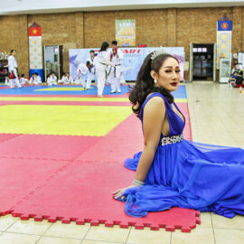 Ladyboy sitting on the martial arts mat, with a battle going on in the background, before the start of the Chiang Mai Pride, gay parade in Chiang Mai, Thailand, photo by Ivan Kralj