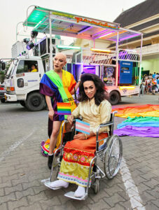 Bold ladyboy in rainbow dress and ladyboy in wheelchair posing at Chiang Mai Pride, gay parade in Chiang Mai, Thailand, photo by Ivan Kralj