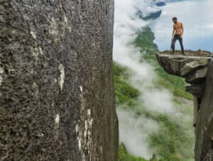 Pipeaway blogger Ivan Kralj standing on the Kalleliklumpen boulder hovering over the cliff in Florli, Lysefjord, one of the best hikes in Norway, photo by Ivan Kralj