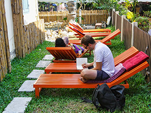 Backpackers resting on the sun loungers in the backyard of the Smile Luang Prabang Hostel, one of the best hostels in Luang Prabang, Laos, photo by Ivan Kralj