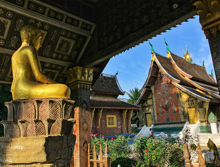 Buddha statue next to the sim of the Wat Xieng Thong, a Buddhist