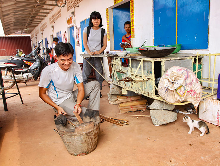 Experience host Ratana Ouch starting a fire for the wok at Backstreet Academy's Fear Factor Challenge cooking class in Siem Reap, Cambodia, a country where they love eating insects, photo by Ivan Kralj