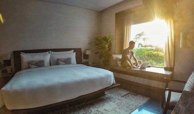 Pipeaway blogger Ivan Kralj sitting on the daybed with bright sun coming through the large window, in the room of Treeline Urban Resort in Siem Reap, Cambodia - what does it take to make it to two years of travel blogging, photo by Ivan Kralj