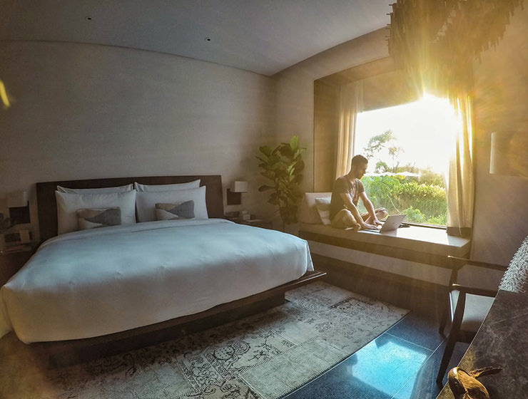 Pipeaway blogger Ivan Kralj sitting on the daybed with bright sun coming through the large window, in the room of Treeline Urban Resort in Siem Reap, Cambodia - what does it take to make it to two years of travel blogging, photo by Ivan Kralj