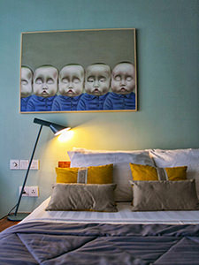 Bed in the room of Rambutan Resort in Phnom Penh, Cambodia, with contemporary art on the wall, photo by Ivan Kralj