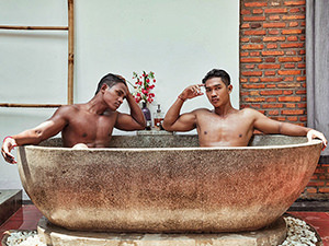 Two models sitting in the stone bath tub at Rambutan Resort, for the purpose of Space Hair Salon and Bar's calendar Men of Cambodia 2018/2019.