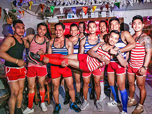 Muscular waiters' staff holding one of them in the air and laughing, at Space Hair Salon and Bar in Phnom Penh, Cambodia, photo by Ivan Kralj