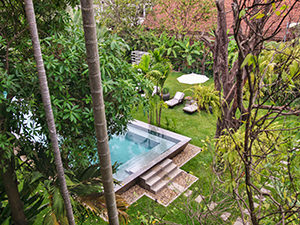 Silver swimming pool behind the lush tropical greenery at Jaya House RiverPark hotel in Siem Reap, Cambodia, photo by Ivan Kralj