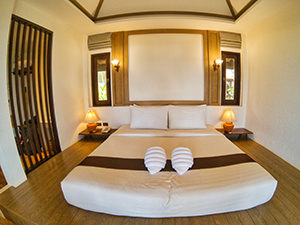 Bed in Mooban Talay Resort beachfront bungalow, with towels wrapped in a from of a seashell, Koh Samet, Thailand, photo by Ivan Kralj