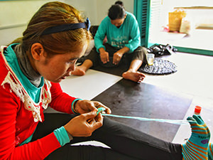 Hardworking women "weaving" the plastic bags into usable objects at Rehash Trash, a social enterprise in Siem Reap, Cambodia, photo by Ivan Kralj