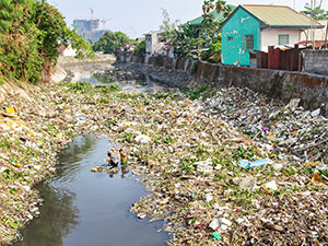 Two boys looking for "valuables" in the garbage-filled river in San Jose district of San Fernando, Pampanga, the Philippines, photo by Ivan Kralj