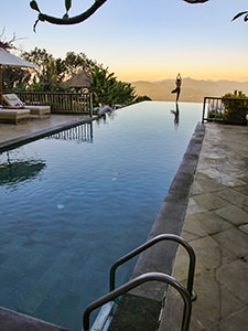 A girl doing yoga and posing for a photo on the edge of the infinity pool at Munduk Moding Plantation in Bali, Indonesia, photo by Ivan Kralj