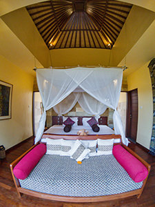 Couch and king size bed under the canopy in the garden suite of Munduk Moding Plantation, nature resort in Bali, Indonesia, photo by Ivan Kralj