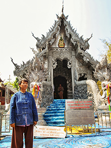 Kru Tu, silversmith artist, standing in front of the Silver Temple she helped decorating, but cannot enter because she is a woman, in Chiang Mai, Thailand, photo by Ivan Kralj