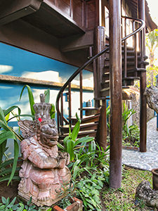 Indonesian sculpture in front of an old Javanese house repurposed as a hotel suite at Tugu Bali, one of Indonesia's best luxury escapes, photo by Ivan Kralj