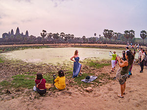 A woman posing for a photo in front of Angkor Wat at sunrise, in Cambodia, photo by Ivan Kralj