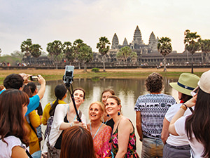 Women taking selfie in the crowd in front of Angkor Wat sunrise, photo by Ivan Kralj